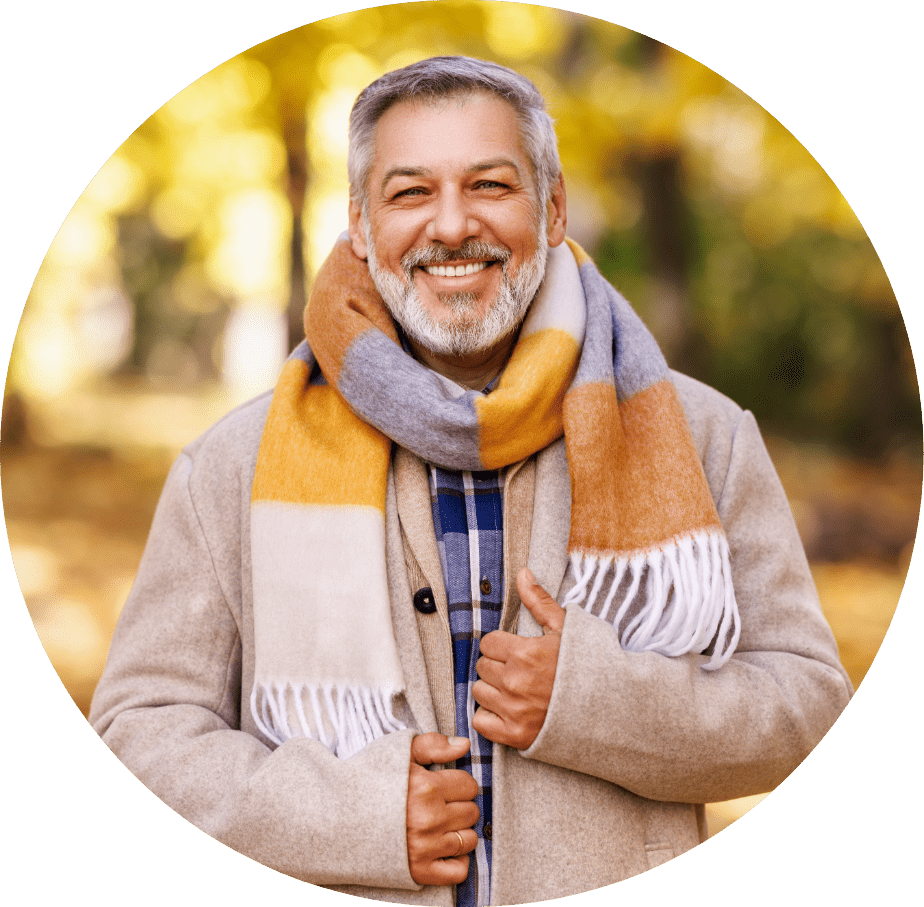 Man smiling with orange and grey scarf.
